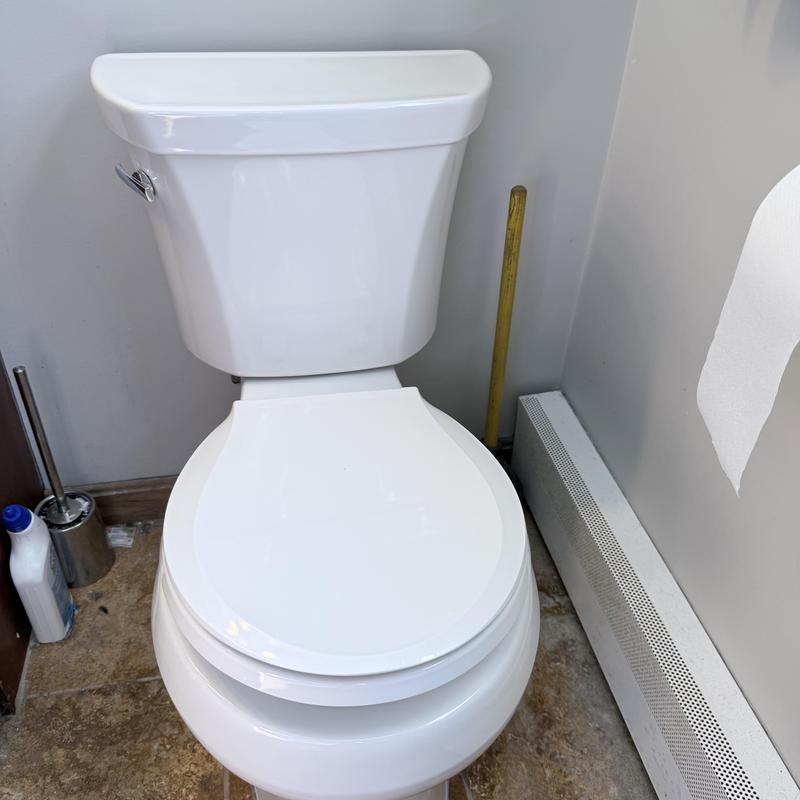 Toilet with closed lid and surrounding bathroom floor