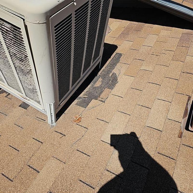 Shingle roof with displaced shingles near HVAC unit Shingle roof with displaced shingles near HVAC unit