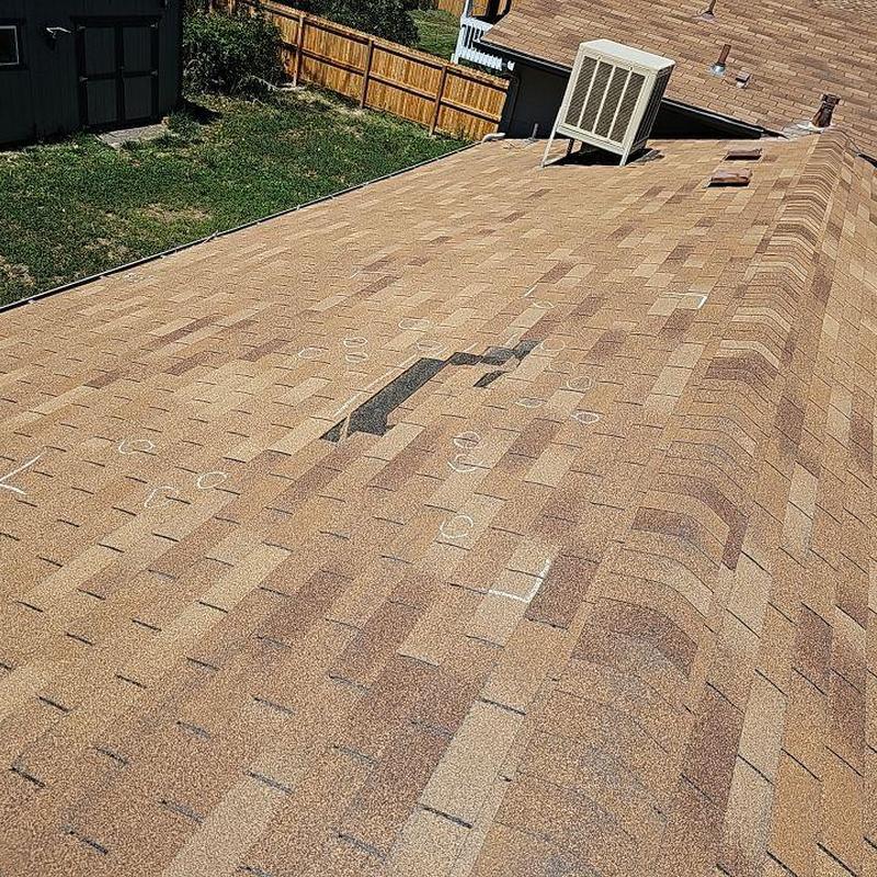 Shingle roof with wind damage and displaced shingles Shingle roof with wind damage and displaced shingles