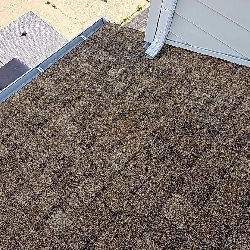 Shingle roof with hail damage near downspout Shingle roof with hail damage near downspout