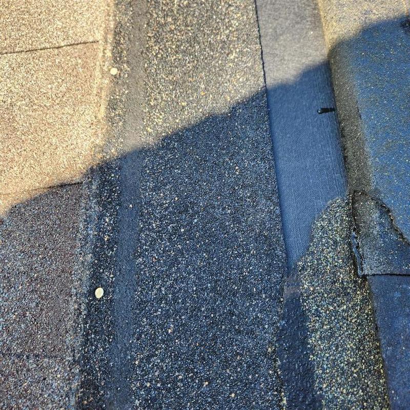 Asphalt shingle roof close-up with nail exposed