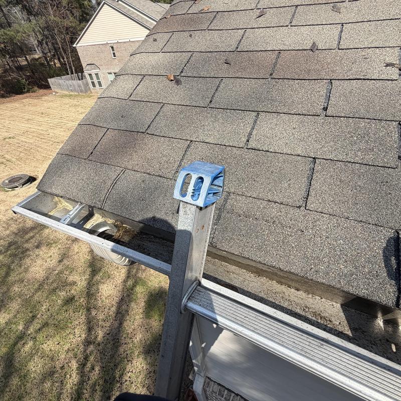 Gutter system cleaned and cleared on asphalt roof