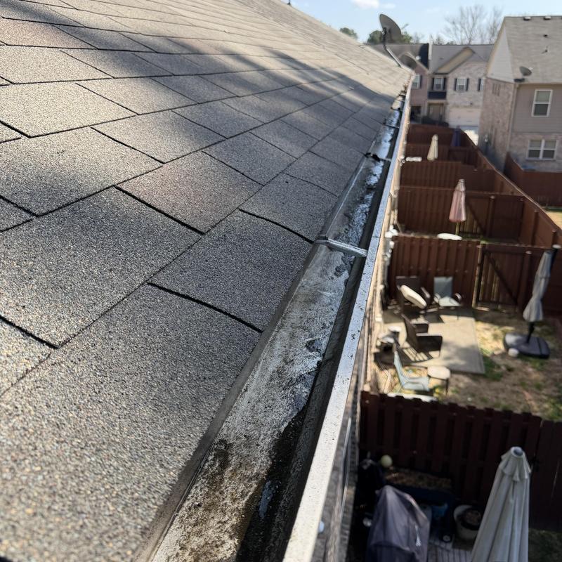 Gutter with debris cleaned from roof edge