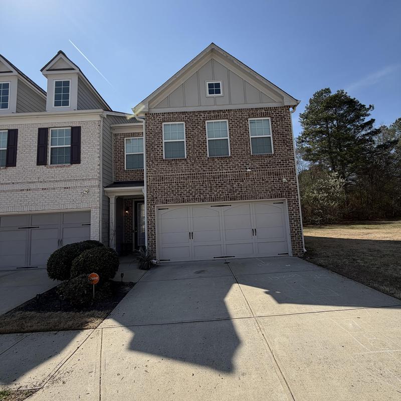 Gutters on brick townhouse exterior with driveway