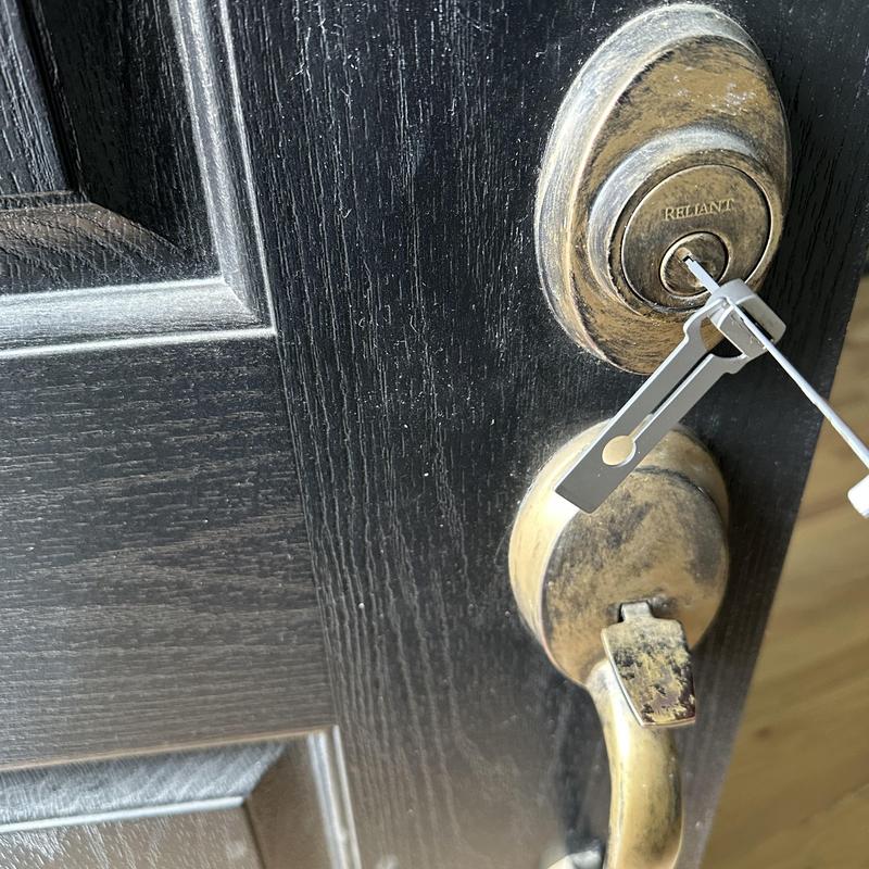 Deadbolt lock unlocking with pick tool on black door