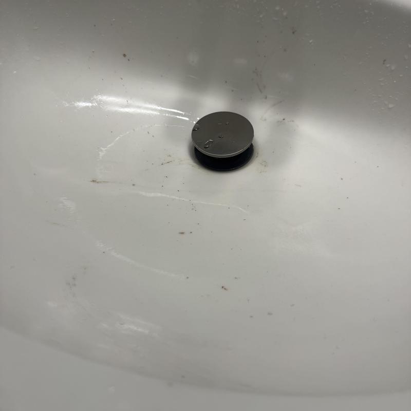 Pop-up drain stopper in white sink bowl