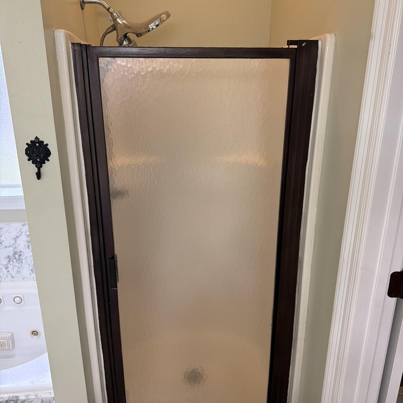 Shower door with textured glass and bronze frame