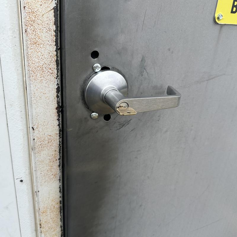 Commercial door lock with key rekeyed on metal door