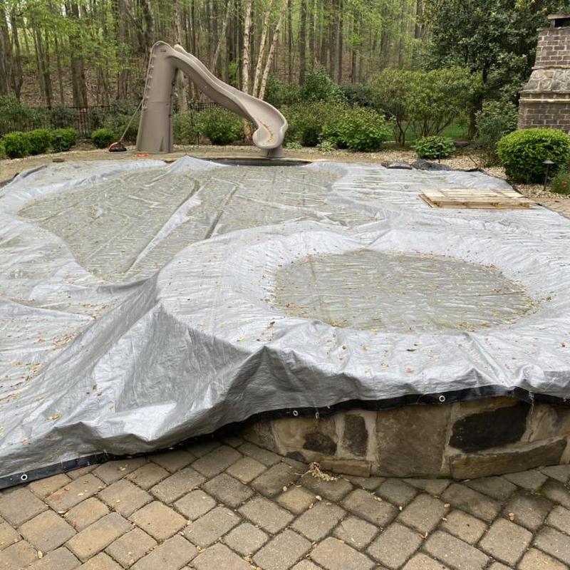 In-ground pool winter cover installation outdoors In-ground pool winter cover installation outdoors