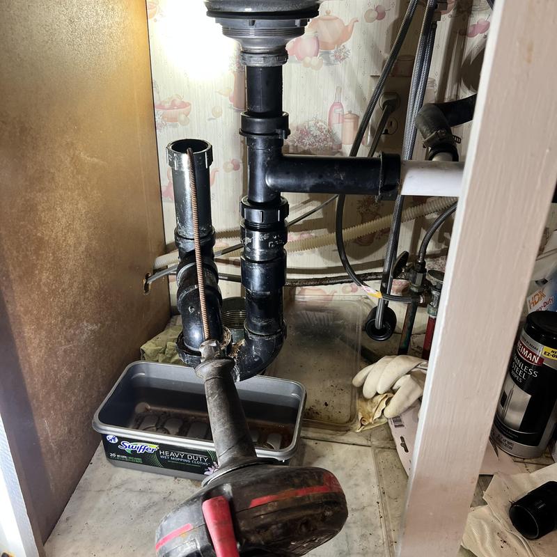 Kitchen sink drain trap with plumbing snake tool