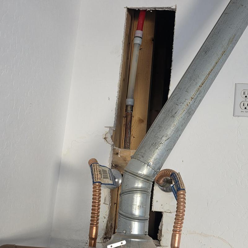Pex pipe above water heater in wall cavity