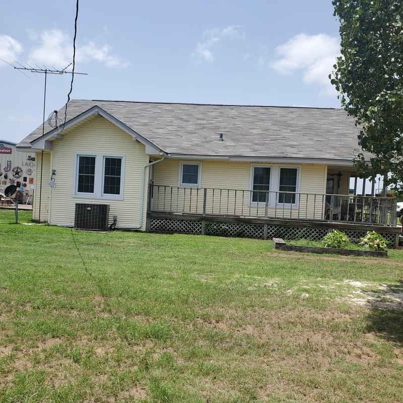 Asphalt shingle roof with hail damage on yellow house