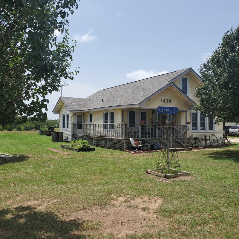 Asphalt shingle roof with hail damage on yellow house