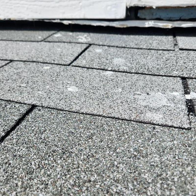 Asphalt roof shingles with potential damage near trim