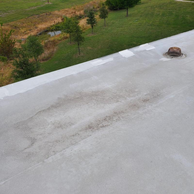 Flat roof surface with hail damage near drain