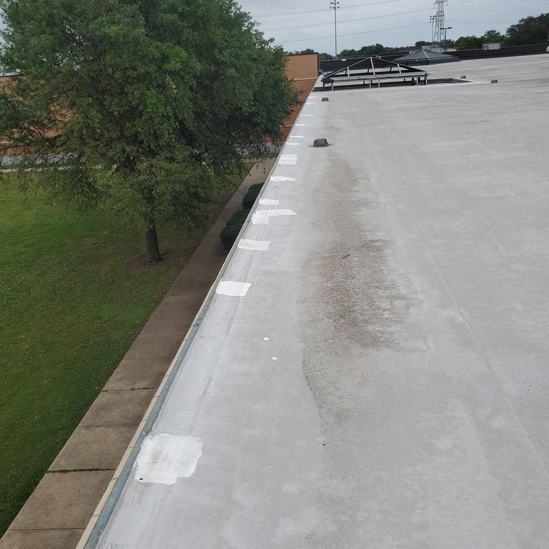 Flat roof membrane with patch repairs and debris buildup