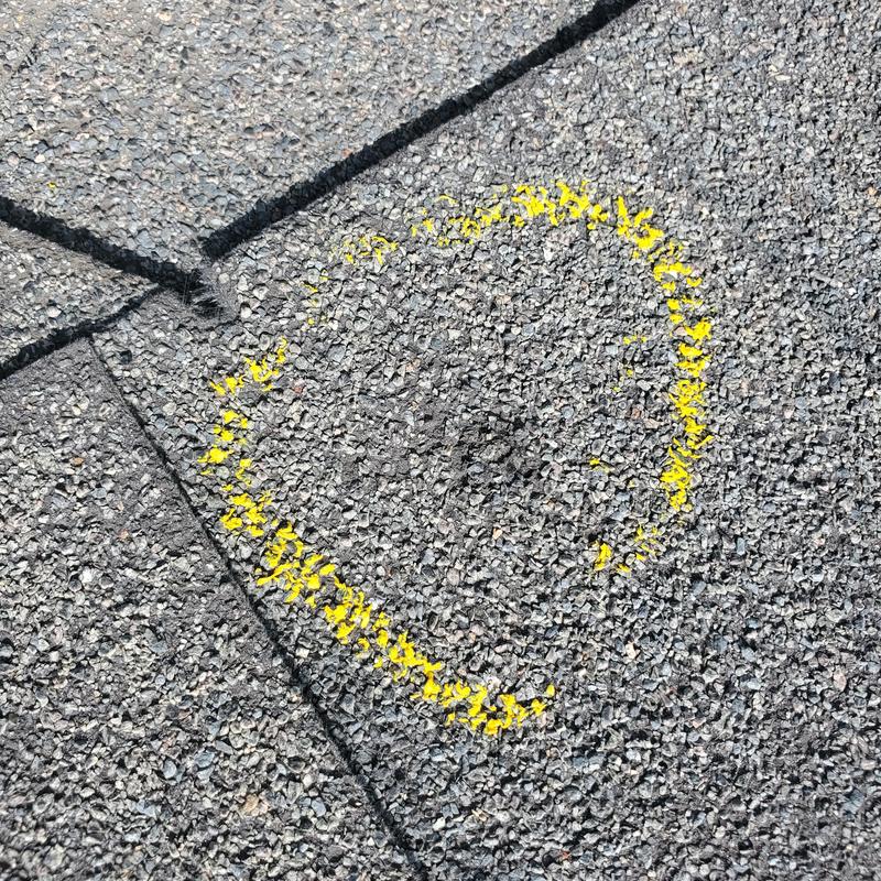 Roof shingle hail damage marked with yellow spray paint