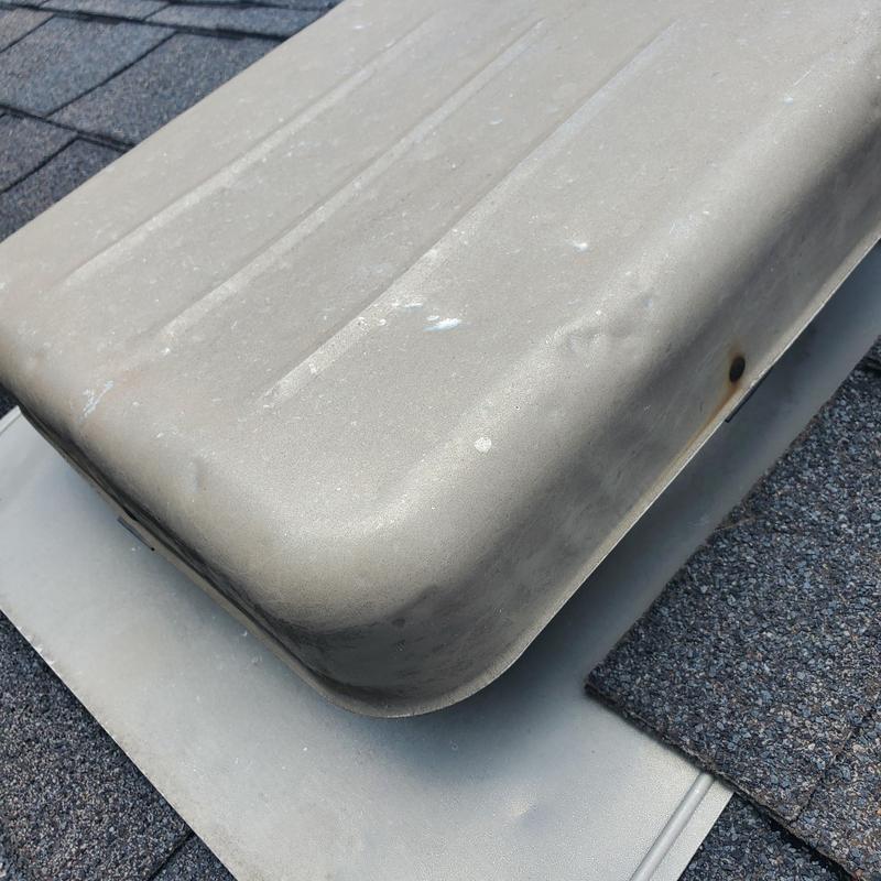 Metal roof vent with hail damage dents on shingles