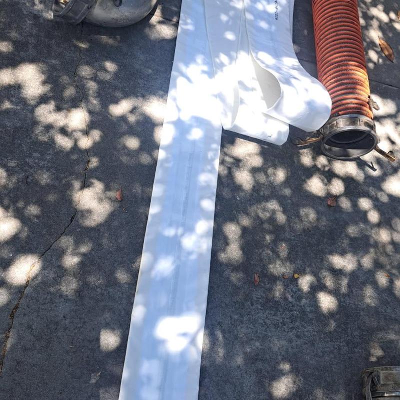 Clay sewer pipe section and white lining wrap on ground