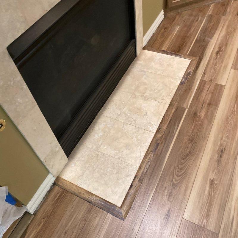 Luxury vinyl plank flooring with tiled fireplace hearth trim