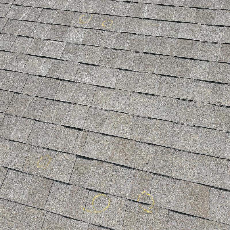 Asphalt roof shingles with hail damage markings