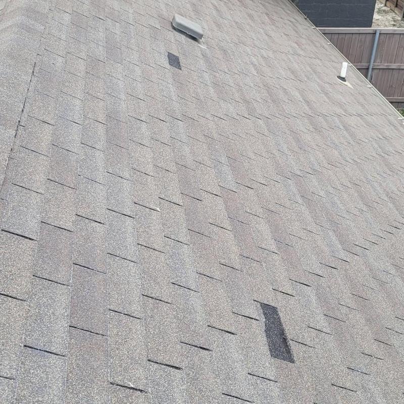 Asphalt shingle roof with hail damage and replacement patch