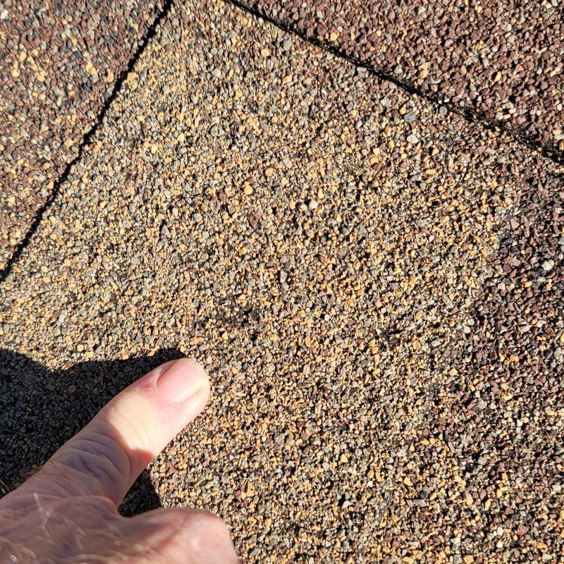 Asphalt roof shingles with hail damage close-up
