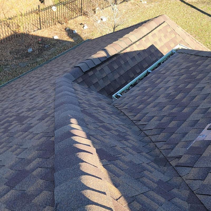 Asphalt shingle roof with hail damage and debris in gutters