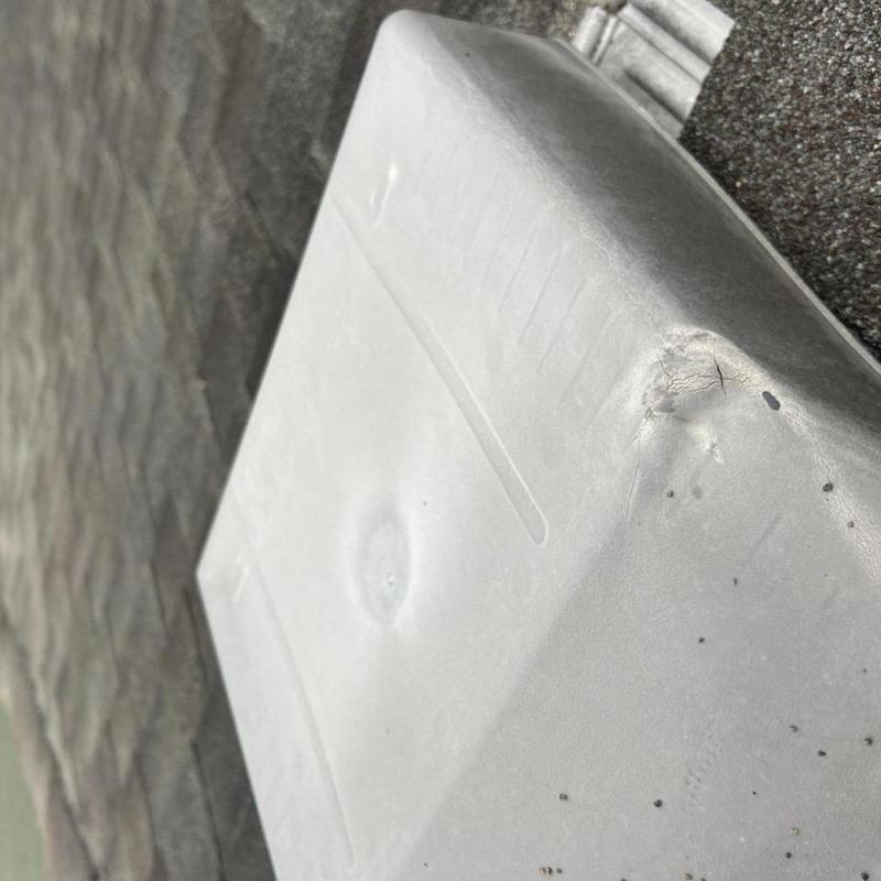 Pipe jack flashing with cracks and dents on shingle roof