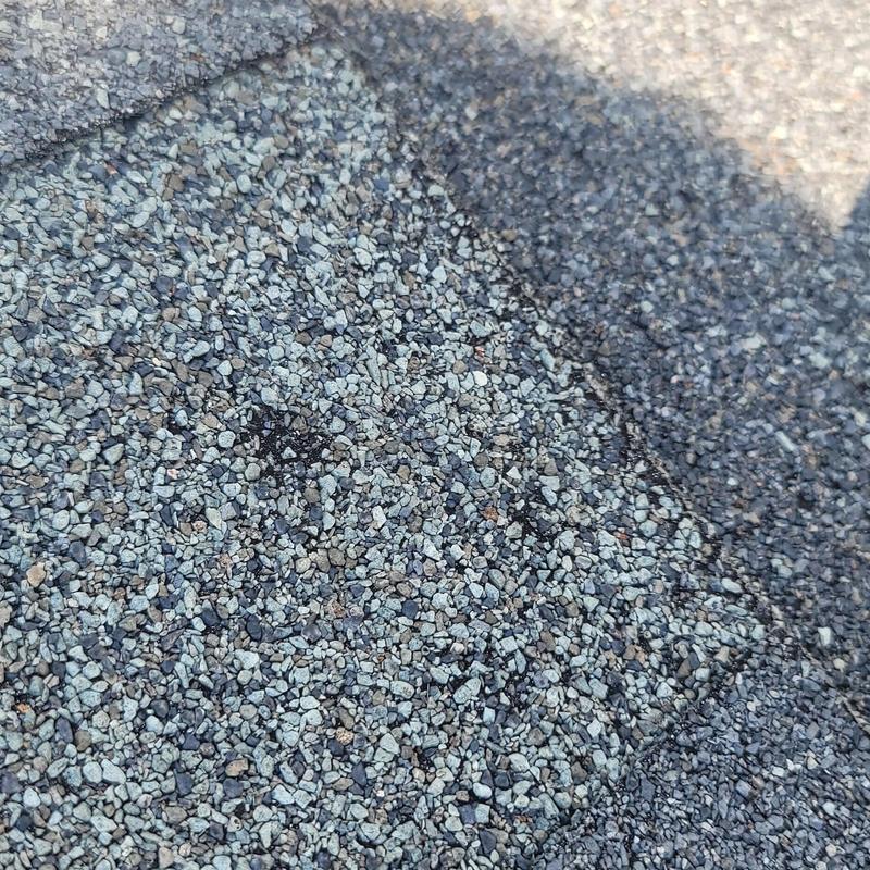 Asphalt roof shingles with hail damage close-up in Terrell TX