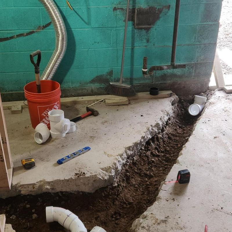 PVC drainage pipe installation in concrete floor trench