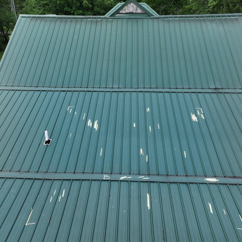 Metal roof panels with hail damage and wear marks