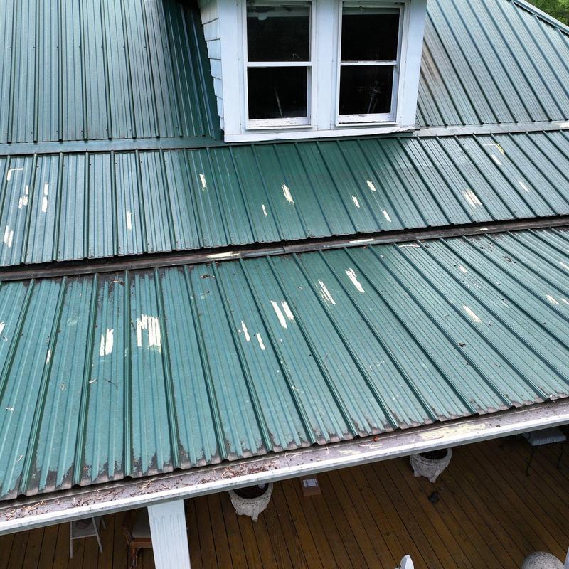 Metal roof with hail damage near dormer window