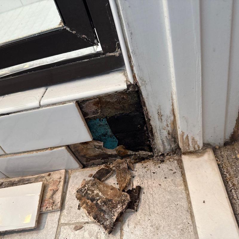 Tile flooring near door frame with water damage