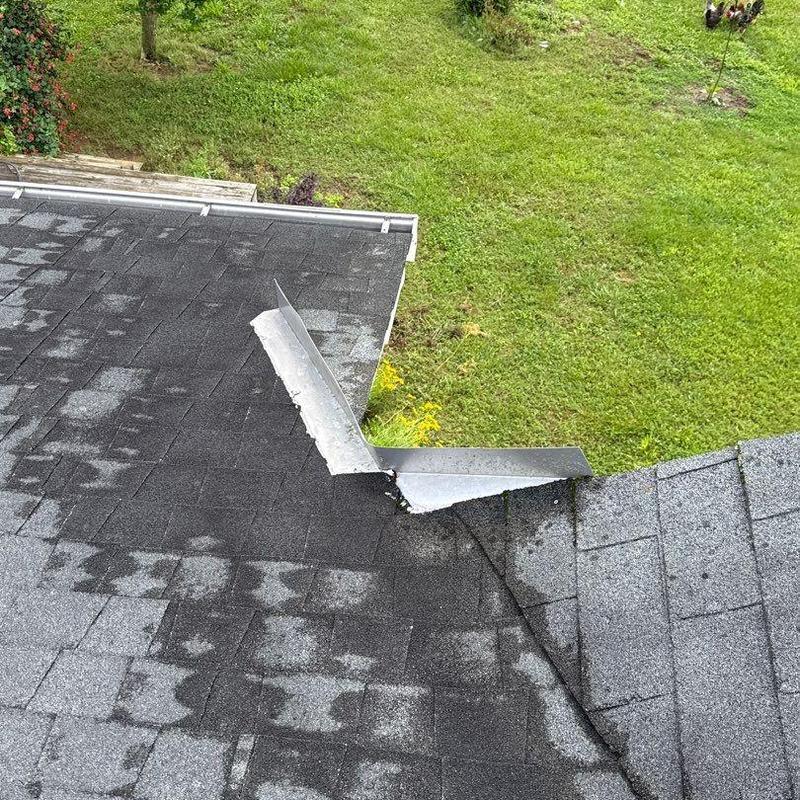Roof flashing with damaged shingles and water stains