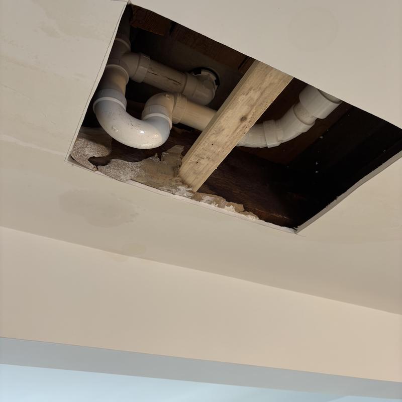Tub shower drain pipes with ceiling damage above kitchen