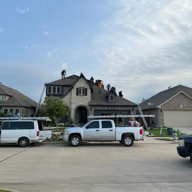 Asphalt shingle roof with workers inspecting hail damage