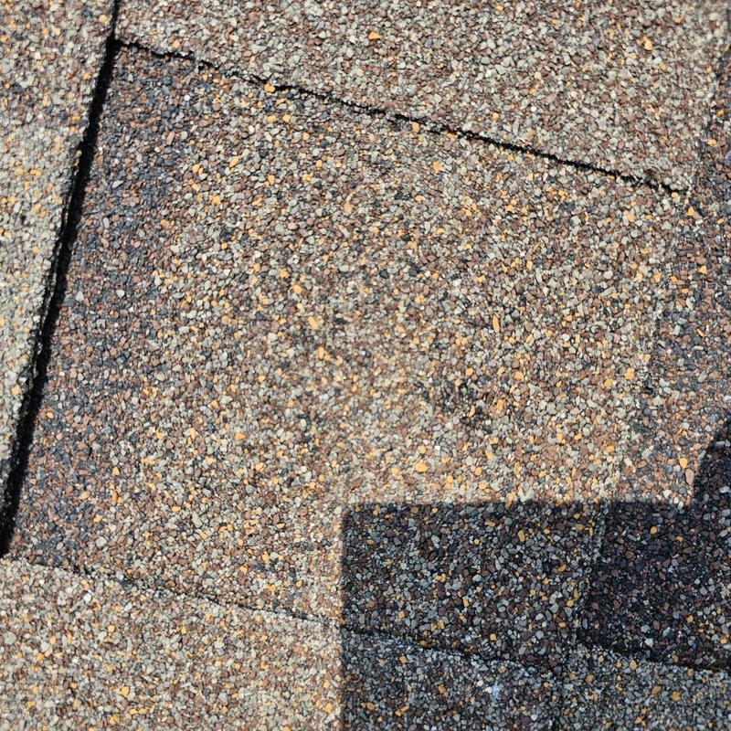 Asphalt roof shingles with cracks from hail damage
