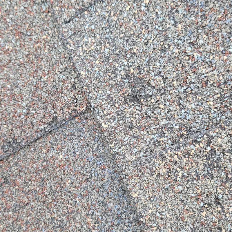 Asphalt roofing shingles with hail damage close-up