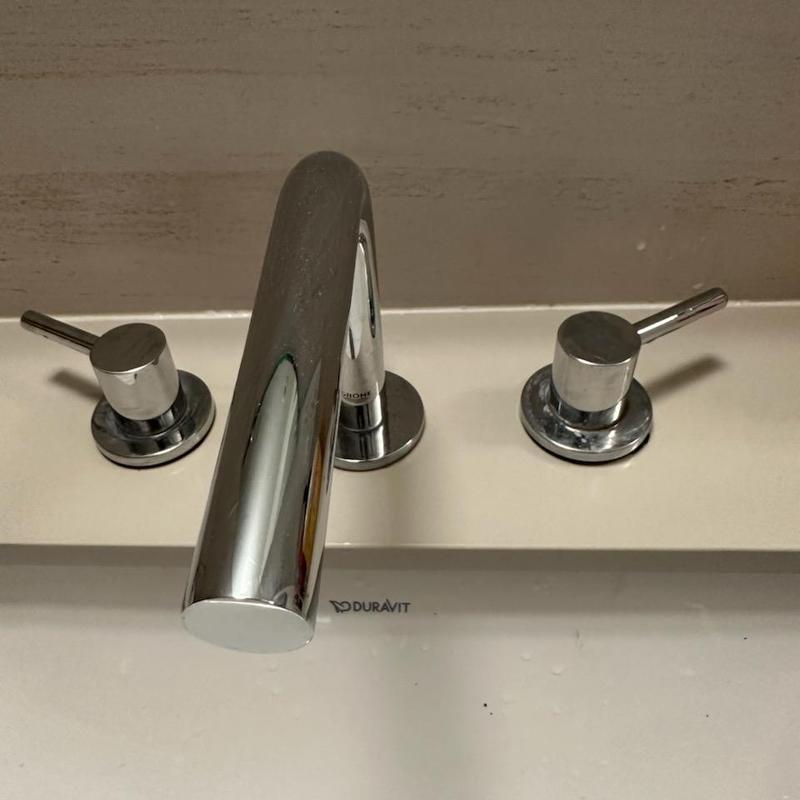 Basin faucet handles with tightened and reinstalled parts