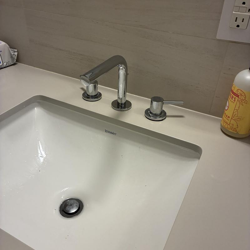 Basin faucet with repaired handles in bathroom sink