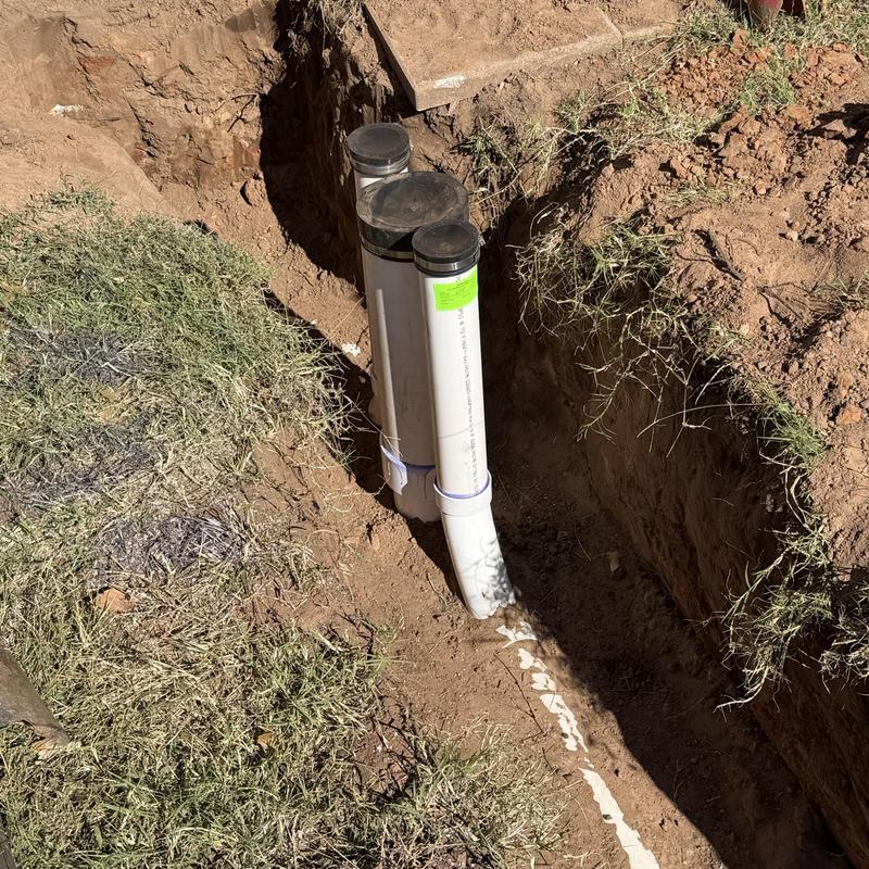 Sewer service line with cleanouts in excavated trench