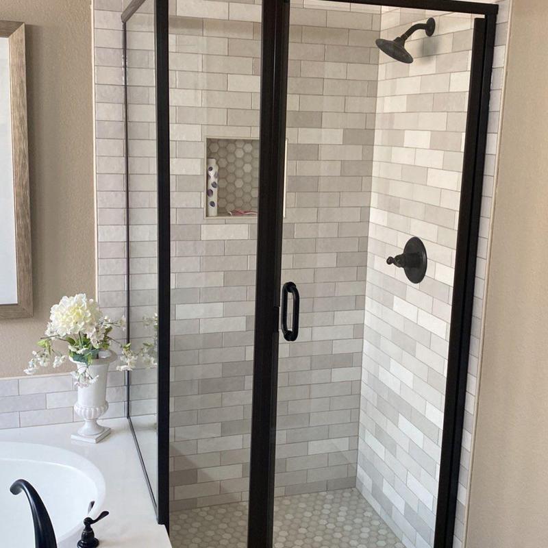 Stand-up shower with black frame and tile walls Stand-up shower with black frame and tile walls