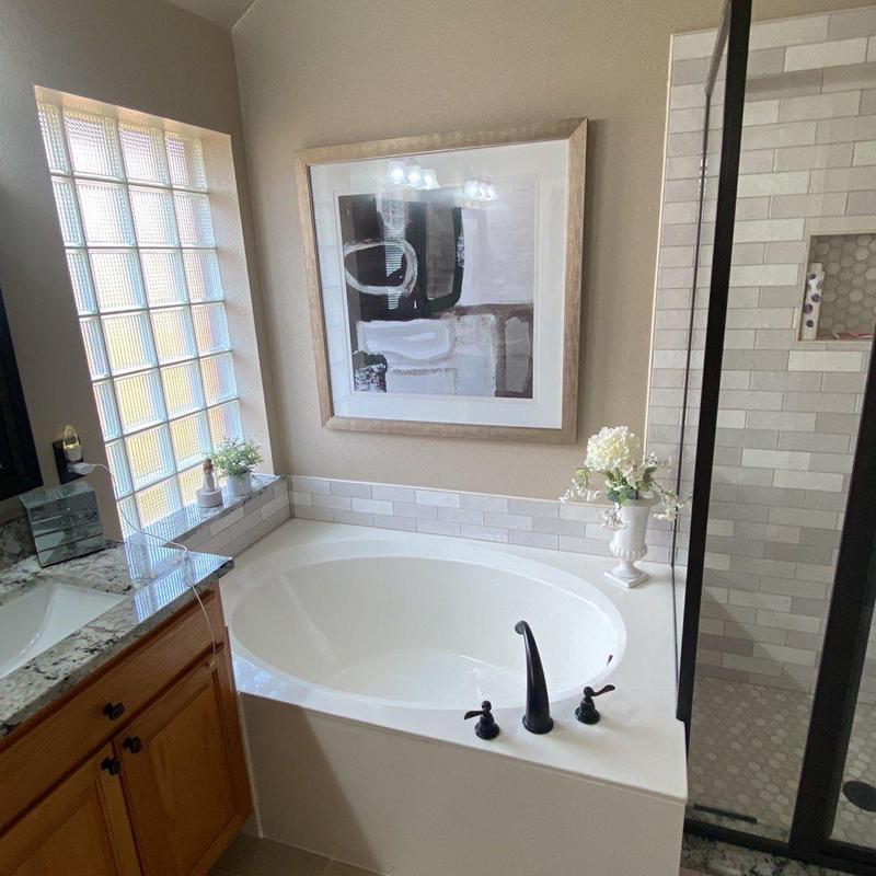 Oval bathtub with black faucet and tile surround Oval bathtub with black faucet and tile surround