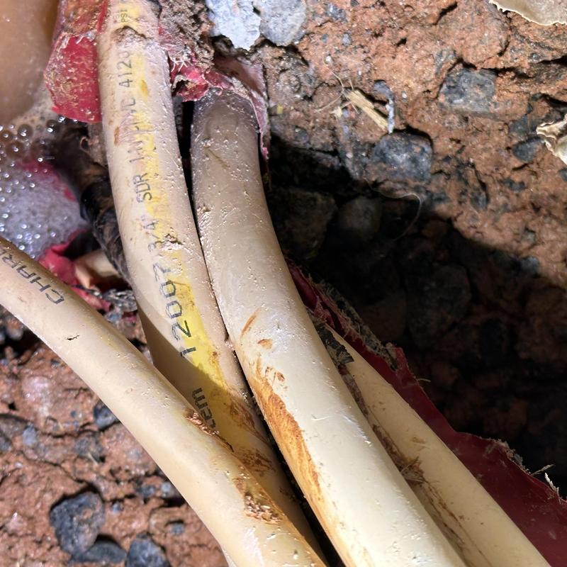 PEX plumbing pipes with slab leak repair in soil cavity