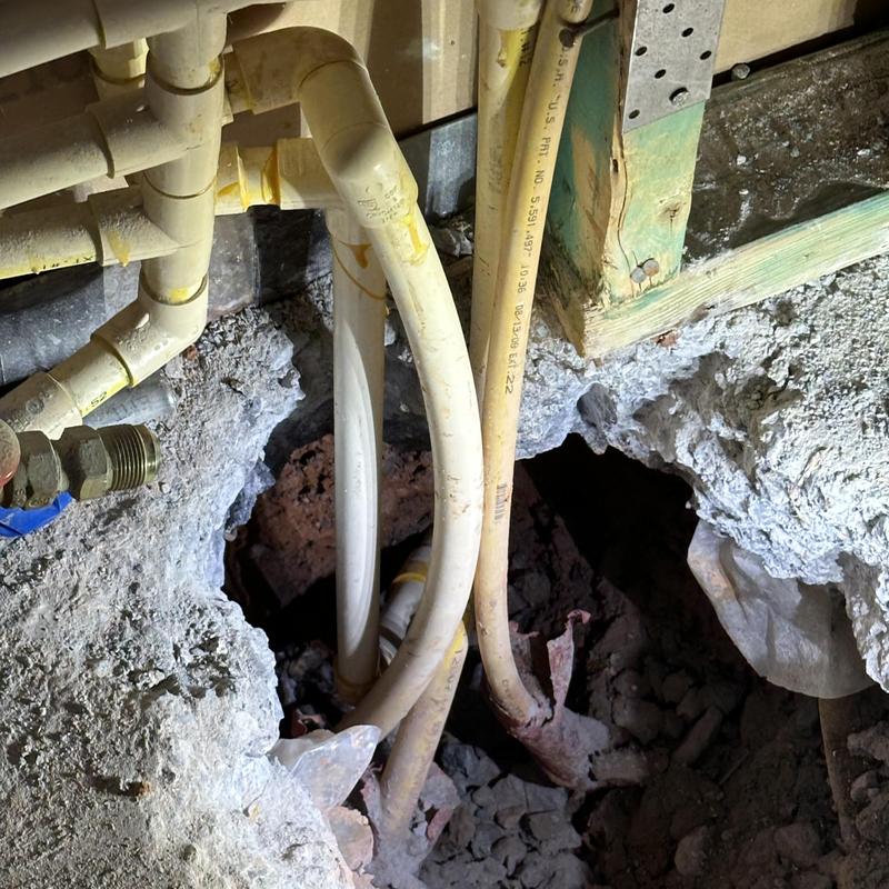 Slab plumbing pipes exposed for leak repair