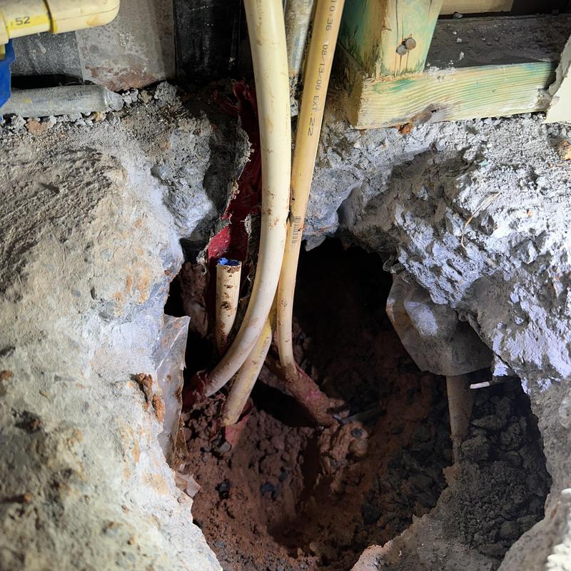 Slab leak repair with exposed plumbing pipes and dirt
