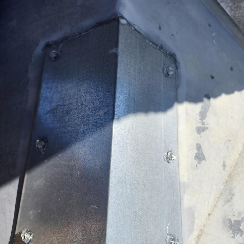 Chimney cricket on metal standing seam roof sealed with caulk Chimney cricket on metal standing seam roof sealed with caulk