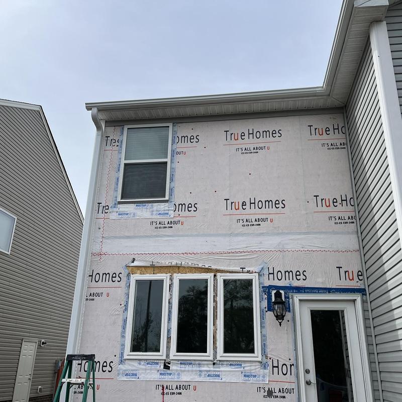 Window installation with weather barrier wrap on house exterior Window installation with weather barrier wrap on house exterior