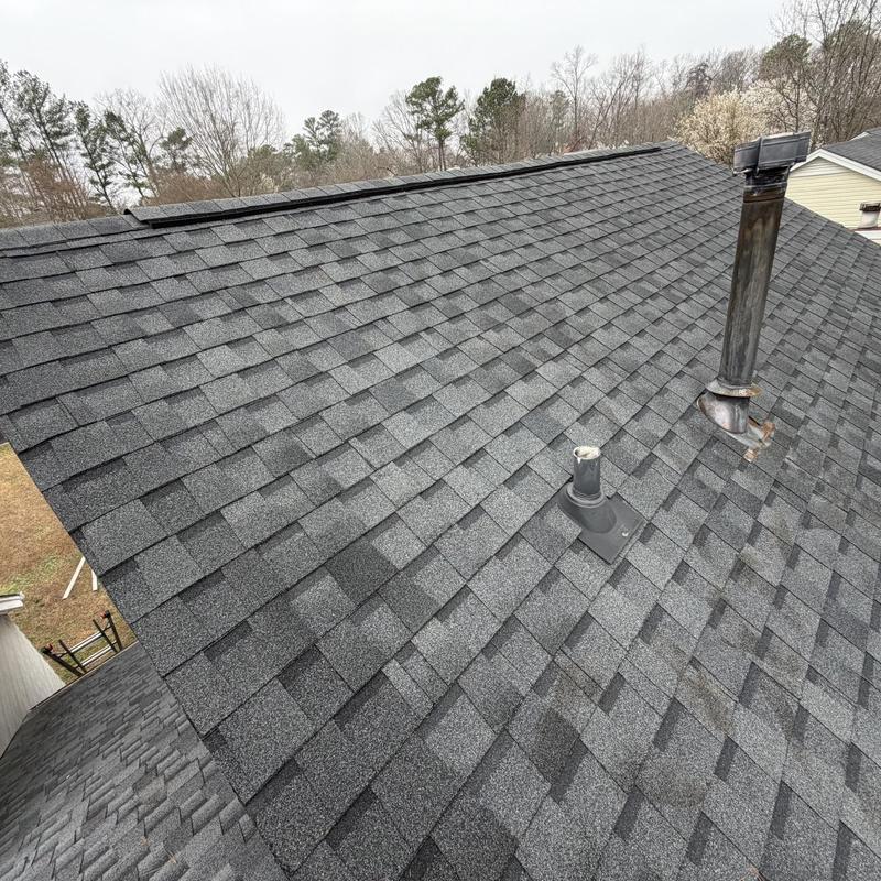 Roof shingles with sealed vent pipes and chimney flashing